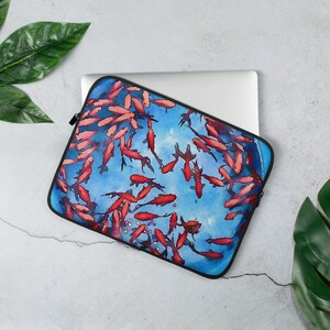 May include: A blue laptop sleeve with a watercolor design of red goldfish swimming in a blue pond. The sleeve is made of a soft, durable material and is perfect for protecting your laptop.