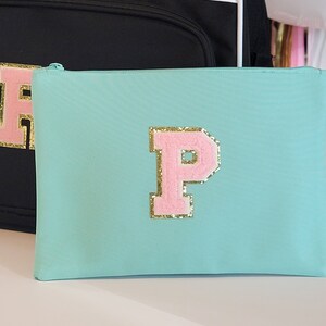 May include: A light blue zippered pouch with a pink felt letter "P" with gold glitter trim.