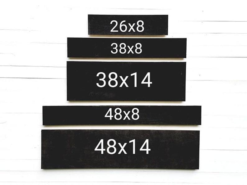 May include: Five black rectangular wooden signs with white text. The signs are stacked in a pyramid shape. The text on the signs reads: 26x8, 38x8, 38x14, 48x8, and 48x14.