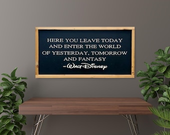 May include: A framed chalkboard with the quote "HERE YOU LEAVE TODAY AND ENTER THE WORLD OF YESTERDAY, TOMORROW AND FANTASY - Walt Disney" in white lettering. The frame is light brown. The chalkboard is above a brown desk.