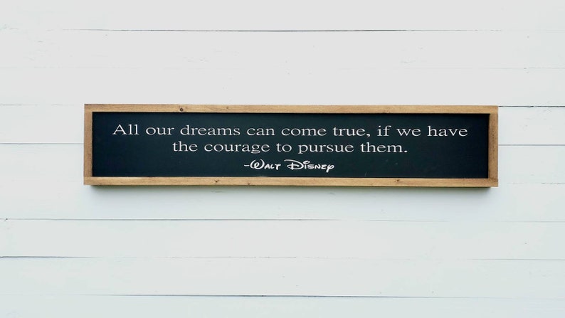 May include: A framed wooden sign with a black background and white text that reads "All our dreams can come true, if we have the courage to pursue them. -WALT DISNEP".