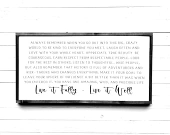 May include: Black and white sign with a wood grain background. The sign has a white border and the text "ALWAYS REMEMBER WHEN YOU GO OUT INTO THIS BIG, CRAZY WORLD TO BE KIND TO EVERYONE YOU MEET. LAUGH OFTEN AND LOVE WITH YOUR WHOLE HEART. APPRECIATE TRUE BEAUTY BE COURAGEOUS. EARN RESPECT FROM RESPECTABLE PEOPLE. LOOK FOR THE BEST IN OTHERS. LISTEN TO THOUGHTFUL, WISE PEOPLE, BUT ALSO REMEMBER THAT HISTORY IS FULL OF ADVENTURERS AND RISK-TAKERS WHO CHANGED EVERYTHING. MAKE IT YOUR GOAL TO LEAVE YOUR SPHERE OF INFLUENCE A BIT BETTER THAN IT WAS WHEN YOU ENTERED IT. YOU HAVE ONE AMAZING, WILD, AND PRECIOUS LIFE Live it Fully - Live it Well"