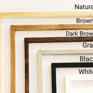 May include: A set of six picture frames in various colors, including natural, brown, dark brown, gray, black, and white. The frames are arranged in a vertical stack, with the natural frame at the top and the white frame at the bottom.