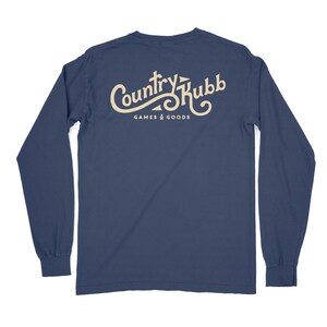 May include: A navy blue long-sleeved t-shirt with a white logo that says "Country Kubb Games & Goods" on the back.