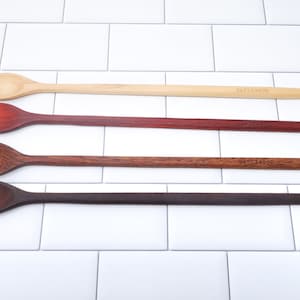May include: Four wooden spoons of different colors and wood types, all with the word "Earlywood" printed on them.