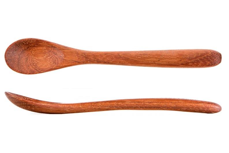 Puede incluir: Una cuchara de madera con un cuenco redondeado y un mango largo y delgado. La cuchara est&aacute; hecha de madera marr&oacute;n claro y tiene un acabado liso y pulido.