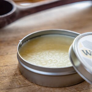 May include: A small tin container of wood conditioner with a white label that reads "Earlywood Wood Conditioner". The lid is open and the conditioner is a light yellow color.