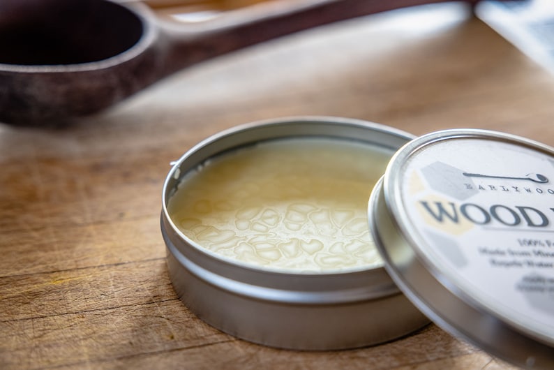 May include: A small tin container of wood conditioner with a white label that reads "Earlywood Wood Conditioner". The lid is open and the conditioner is a light yellow color.