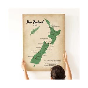 Può includere: Un poster rettangolare da parete con una mappa verde della Nuova Zelanda su uno sfondo beige effetto carta invecchiata. La mappa mostra un itinerario di viaggio con punti rossi che collegano città e luoghi, una felce e il testo New Zealand 2026.