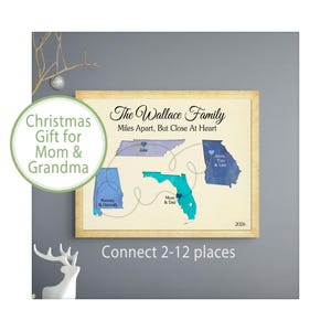 May include: A framed wall art print featuring a map of four US states in blue watercolor tones, connected by thin lines. Text reads: The Wallace Family, Miles Apart, But Close At Heart, 2026, and names like Julie, Jenny, Tom, Lexi, Kenney, Hannah, Mom & Dad.
