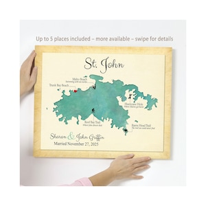 May include: A framed map of St. John, with teal-colored landmasses and labeled locations. The map includes the names Sharon & John Griffin and their wedding date, November 27, 2025. Text at the top says "Up to 5 places included - more available - swipe for details."
