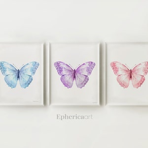 May include: Three framed watercolor butterfly prints. The butterflies are in shades of blue, purple, and pink. The artwork is displayed on a white background. The text "Ephericaart" is at the bottom of the image.