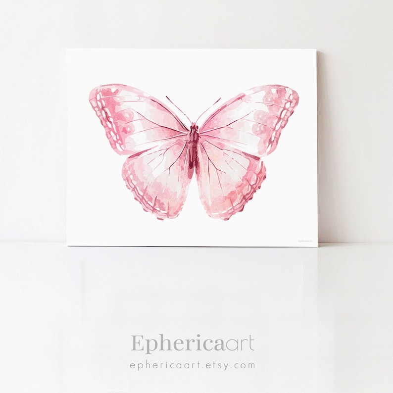 May include: A watercolor painting of a pink butterfly with detailed wing patterns. The artwork is displayed on a white square canvas. The butterfly's wings are a gradient of pink hues, and the artwork is signed by the artist.