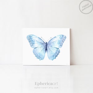 Op de afbeelding: Een aquarelillustratie van een vlinder in lichtblauwe en witte tinten. De vlinder is gecentreerd op een witte rechthoekige achtergrond. In de rechterbovenhoek staat een cirkelvormige stempel met Digital Download. De tekst Ephericaart staat eronder.