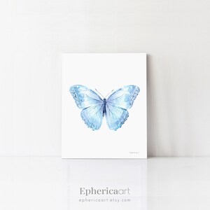 May include: A watercolor print of a light blue butterfly with detailed wing patterns. The artwork is displayed on a white background. The artist's name, "Ephericaart", and their Etsy shop URL are printed at the bottom.