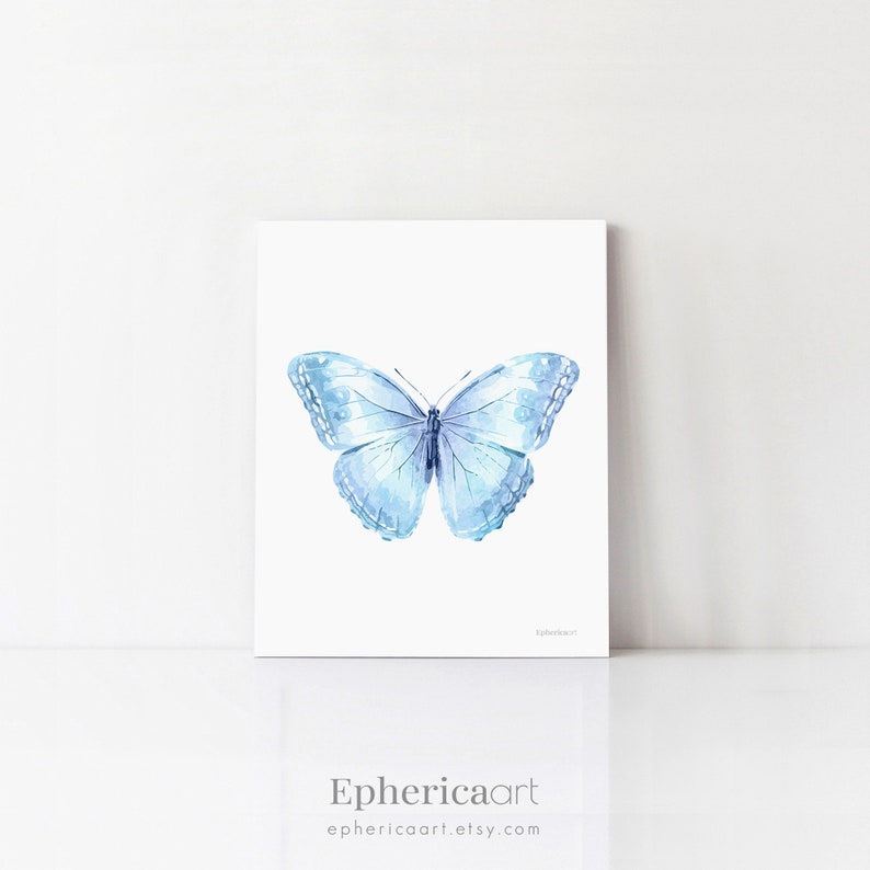 May include: A watercolor print of a light blue butterfly with detailed wing patterns. The artwork is displayed on a white background. The artist's name, "Ephericaart", and their Etsy shop URL are printed at the bottom.