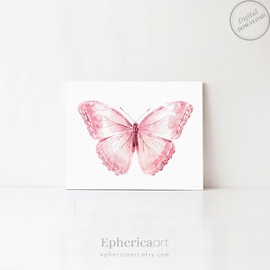 May include: A watercolor print of a pink butterfly with detailed wing patterns. The butterfly is centered on a white background. The print has a digital download label in the upper right corner. The artist's name, Ephericaart, is printed at the bottom.