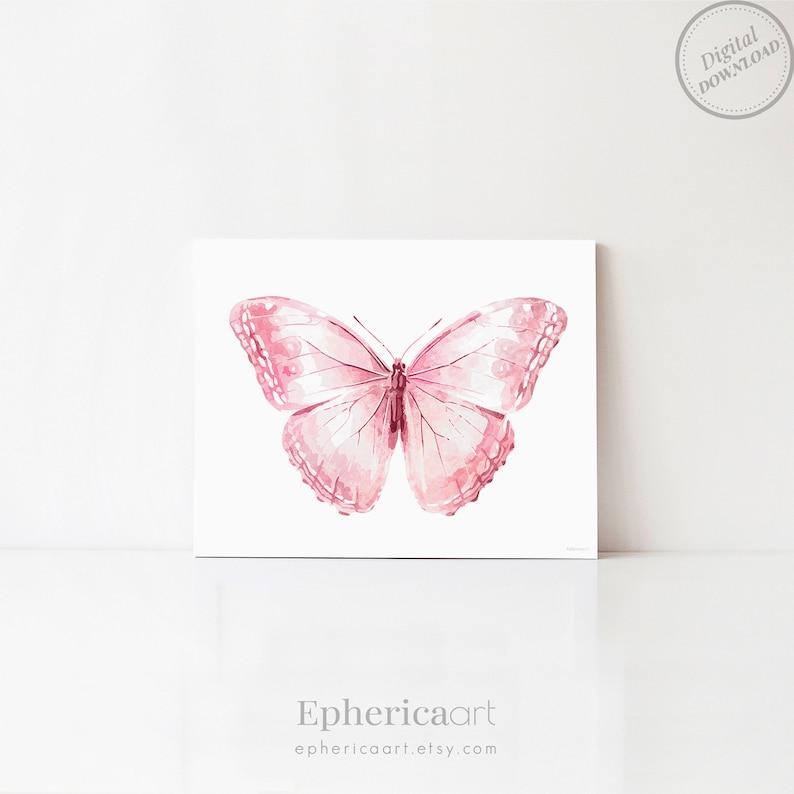 May include: A watercolor print of a pink butterfly with detailed wing patterns. The butterfly is centered on a white background. The print has a digital download label in the upper right corner. The artist's name, Ephericaart, is printed at the bottom.