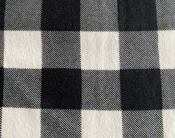 May include: Black and white checkered fabric with a subtle texture. The fabric has a classic plaid pattern.