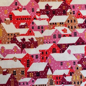 May include: A repeating pattern of pink, red, and brown houses with white snow-covered roofs. The houses have small windows and are set against a white background with small brown dots representing falling snow.