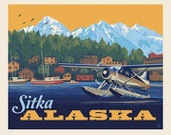 May include: A vintage-style travel poster for Sitka, Alaska, featuring a seaplane on the water with a backdrop of snow-capped mountains, trees, and buildings. The poster has a cream-colored border and the text "Sitka ALASKA" in a stylized font.