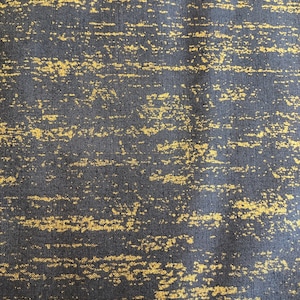 May include: A dark gray fabric with a gold metallic pattern. The pattern is a series of horizontal lines and swirls.