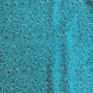 May include: Close-up of a teal fabric with a repeating pattern of swirling, stylized leaves and vines. The design features varying shades of teal and a lighter, almost white, background, creating a textured, organic look. The fabric appears to be a decorative textile.