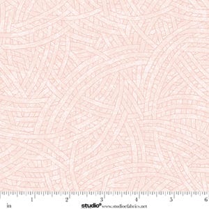 May include: A light pink fabric featuring a repeating pattern of intersecting curved lines that create a woven, basket-like texture. A white ruler is visible at the bottom edge, showing measurements in inches from zero to six inches.