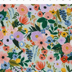 May include: A fabric with a floral design on a pale green background. The pattern is densely packed with flowers in pink, purple, orange, blue, and yellow, with green foliage. The flowers vary in size and shape, creating a detailed and colourful design.