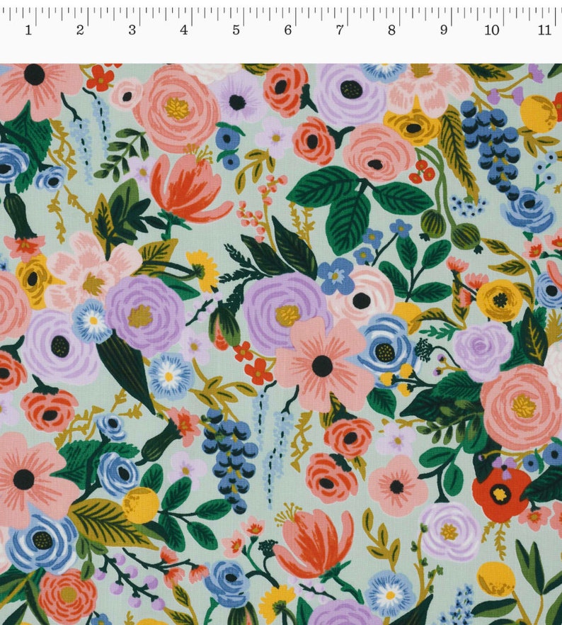 May include: A fabric with a floral design on a pale green background. The pattern is densely packed with flowers in pink, purple, orange, blue, and yellow, with green foliage. The flowers vary in size and shape, creating a detailed and colourful design.