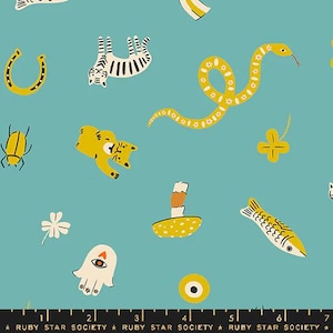 May include: A teal blue fabric with a repeating pattern of yellow and white illustrations. The illustrations include a snake, a horseshoe, a cat, a fish, a mushroom, a clover, a beetle, a hand with an eye, and a star. The text "RUBY STAR SOCIETY" is repeated at the bottom of the fabric.
