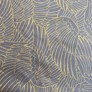 May include: A fabric with a repeating pattern of gold wings on a gray background.
