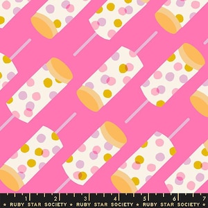 May include: A pink fabric with a repeating pattern of white popsicles with yellow, pink, and purple polka dots. The popsicles have a white stick and are arranged diagonally on the fabric.