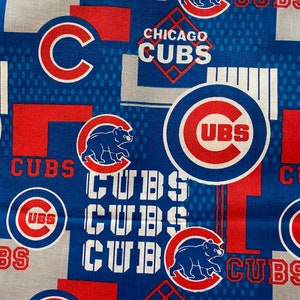 May include: A blue and red fabric with a repeating pattern of the Chicago Cubs logo. The logo features a red "C" with a white outline, a red bear, and the words "Chicago Cubs" in white. The fabric also features the words "Cubs" in white and the words "UBS" in white.