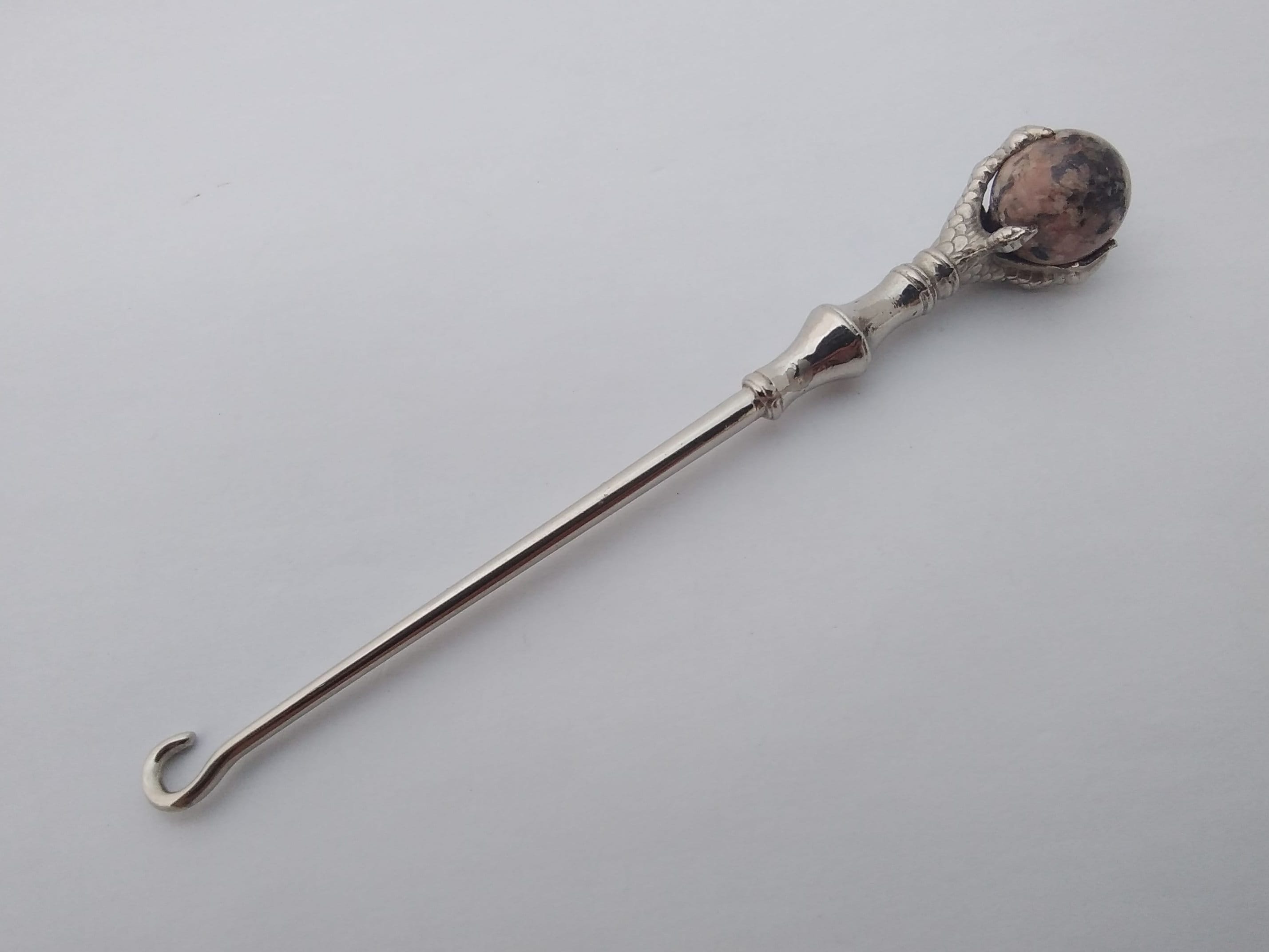 Quality antique button hook with claw handle holding marble ball
