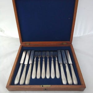 Cased antique set of 12 silver plated dessert cutlery with fluted handles