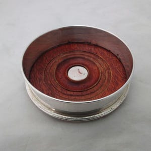 Silver plated on copper wine bottle coaster with turned wooden base