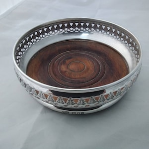 Lovely solid sterling silver wine bottle coaster with turned wooden base - decorative pierced design, London 1971