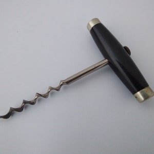 May include: A vintage corkscrew with a black wooden handle and a silver metal screw. The handle has a silver metal cap on each end.