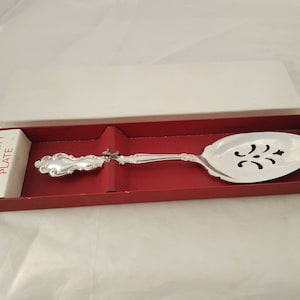 May include: A silver Community Plate pie server with an ornate handle and a pierced design in the blade. The server is in a red box with a white label that reads "Community Plate".