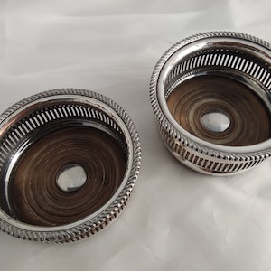 Small antique pair of silver plated on copper bottle coasters