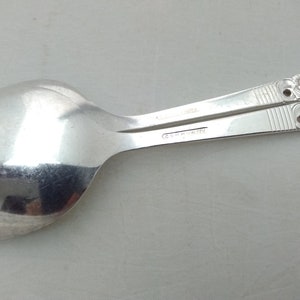 May include: A silver spoon with a floral design on the handle. The spoon is marked "C.H. MARTIN" on the back.