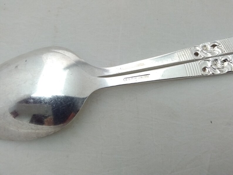 May include: A silver spoon with a floral design on the handle. The spoon is marked "C.H. MARTIN" on the back.