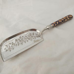 Beautiful antique silver plated crumb scoop with vibrant porcelain handle