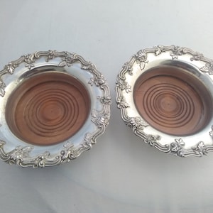 Very impressive large heavy pair of silver plated on copper bottle coasters with turned wooden bases