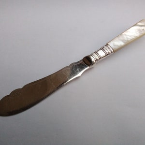 Antique silver plated butter spreader with carved mother of pearl handle