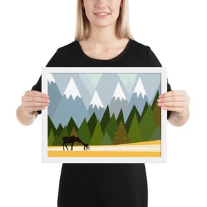 Paysage boisé avec la maman d’orignal et la silhouette encadrée de chéri d’une famille d’orignal montagnes enneigées et des pins