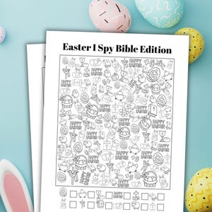 May include: A black and white Easter I Spy Bible Edition activity sheet. The sheet is filled with Easter-themed images and the words "Happy Easter". Colourful Easter eggs and bunny ears are in the background.