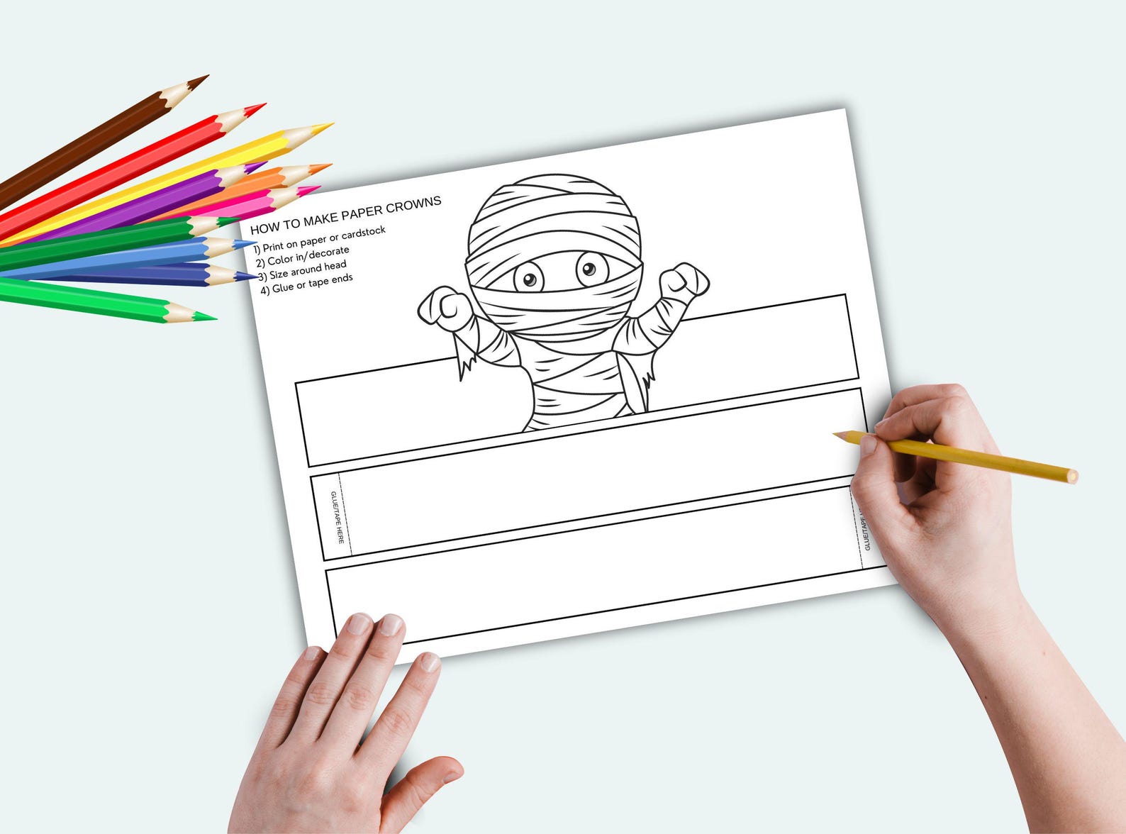 A Wrapped Mummy Character Black-and-white mummy crown printable being colored on a table.