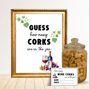May include: A framed sign with the text "GUESS how many CORKS are in the jar" next to a glass jar filled with corks. A small card reads "How many WINE CORKS are in the jar?" with spaces for a name and guess.
